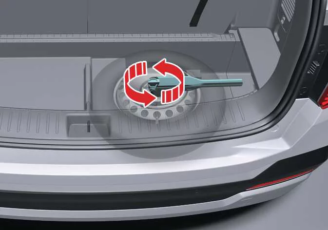 Connecting the socket wrench to the lowering mechanism bolt inside a Kia Sorento cargo bay